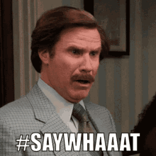 A Man In A Suit And Tie Is Making A Funny Face And Saying Say Whaat GIF