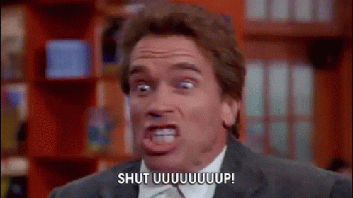 A Man In A Suit And Tie Is Making A Funny Face And Saying Shut Uuuuuuup . GIF