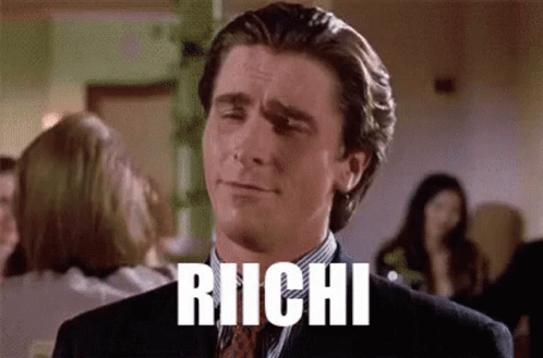 A Man In A Suit And Tie Is Making A Funny Face And The Word Richi Is Written On His Face . GIF