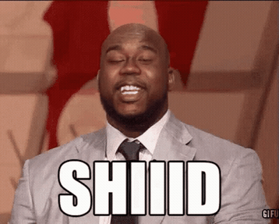 A Man In A Suit And Tie Is Making A Funny Face And The Word Shiiid Is On His Face . GIF