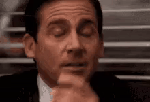 A Man In A Suit And Tie Is Making A Funny Face . GIF