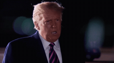 A Man In A Suit And Tie Is Making A Funny Face GIF