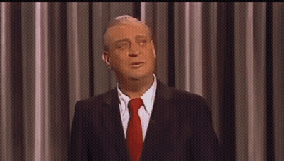 A Man In A Suit And Tie Is Making A Funny Face GIF