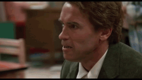 A Man In A Suit And Tie Is Making A Funny Face In A Blurry Photo . GIF