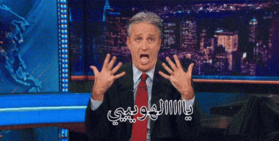 A Man In A Suit And Tie Is Making A Funny Face In Front Of A City Skyline GIF