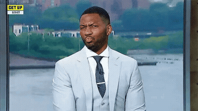 A Man In A Suit And Tie Is Making A Funny Face On A Television Show . GIF