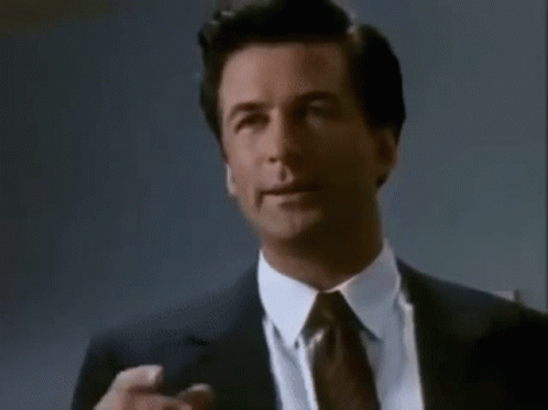 A Man In A Suit And Tie Is Making A Funny Face . GIF