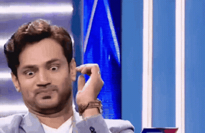A Man In A Suit And Tie Is Making A Funny Face GIF