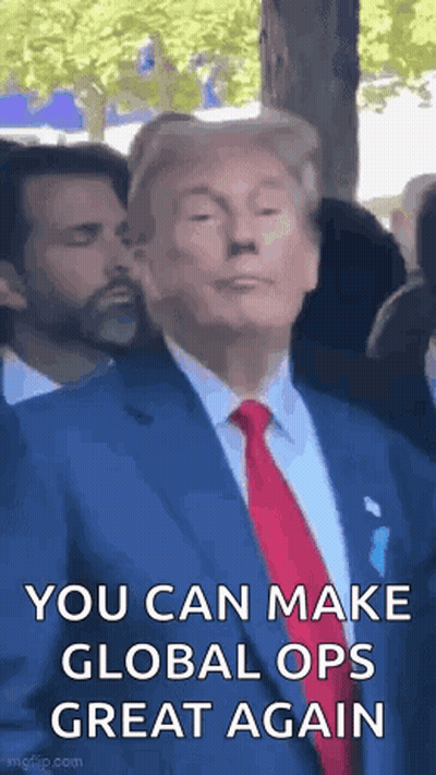 A Man In A Suit And Tie Is Making A Funny Face While Standing In Front Of A Crowd . GIF