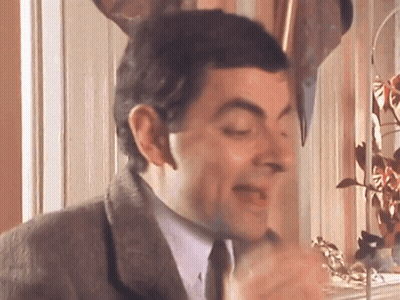 A Man In A Suit And Tie Is Making A Funny Face With His Eyes Closed GIF
