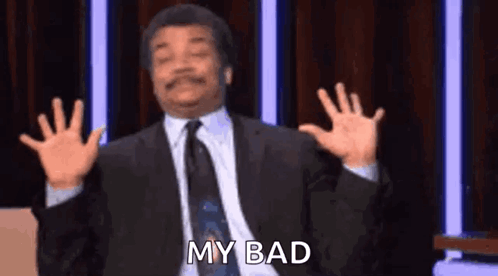 A Man In A Suit And Tie Is Making A Funny Face With His Hands In The Air . GIF