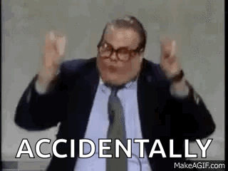 A Man In A Suit And Tie Is Making A Funny Face With His Hands In The Air . GIF