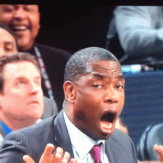 A Man In A Suit And Tie Is Making A Funny Face With His Mouth Open GIF