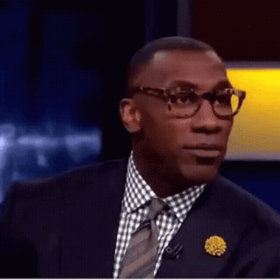 A Man In A Suit And Tie Is Making A Funny Face With His Mouth Open . GIF