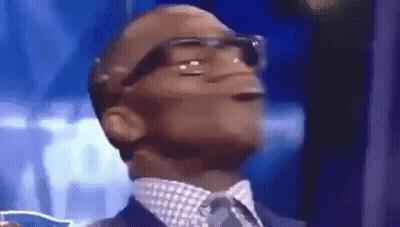 A Man In A Suit And Tie Is Making A Funny Face With His Mouth Open . GIF