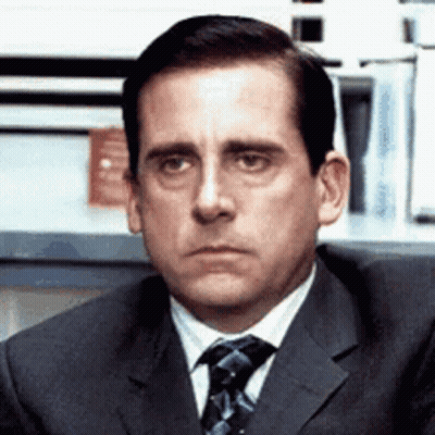 A Man In A Suit And Tie Is Making A Funny Face . GIF