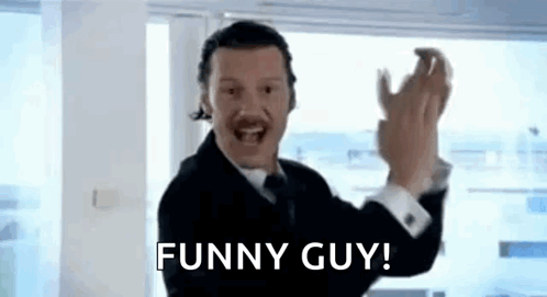 A Man In A Suit And Tie Is Making A Funny Guy Gesture While Wearing A Headset . GIF