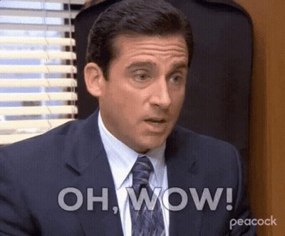 A Man In A Suit And Tie Is Making A Surprised Face And Saying Oh Wow . GIF
