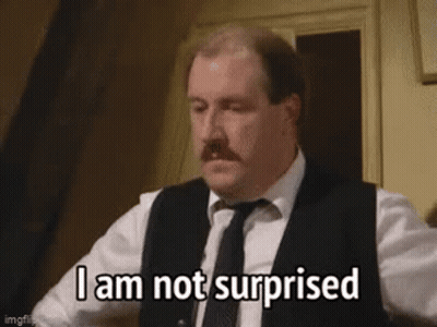 A Man In A Suit And Tie Is Making A Surprised Face . GIF