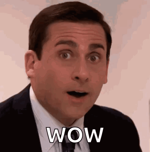 A Man In A Suit And Tie Is Making A Surprised Face While Saying Wow . GIF