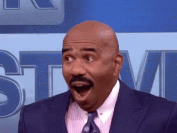 A Man In A Suit And Tie Is Making A Surprised Face With His Mouth Open GIF