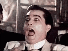 A Man In A Suit And Tie Is Making A Surprised Face With His Mouth Open . GIF