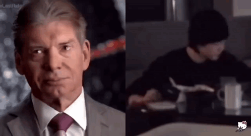 A Man In A Suit And Tie Is Next To A Man In A Black Sweater GIF