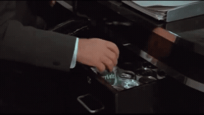 A Man In A Suit And Tie Is Opening A Can Of Beer GIF