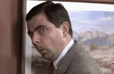 A Man In A Suit And Tie Is Peeking Out From Behind A Picture On A Wall . GIF