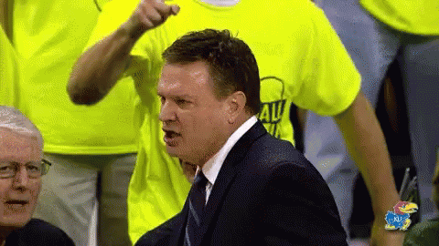 A Man In A Suit And Tie Is Pointing At Someone Wearing A Yellow Shirt That Says All Team GIF