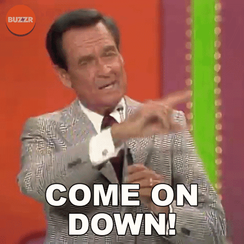 A Man In A Suit And Tie Is Pointing At Something And Says Come On Down GIF