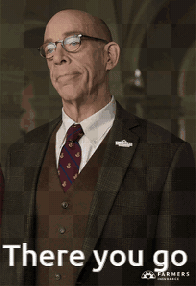 A Man In A Suit And Tie Is Pointing At Something With The Words There You Go Below Him GIF