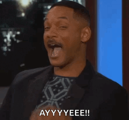 A Man In A Suit And Tie Is Pointing At The Camera And Saying Ayy Yeee . GIF