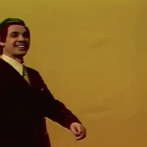 Man In Suit And Tie Pointing And Smiling GIF