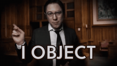 A Man In A Suit And Tie Is Pointing At The Camera With The Words I Object Behind Him GIF
