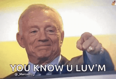 A Man In A Suit And Tie Is Pointing At The Camera With The Words You Know U Luv 'M Written Below Him . GIF