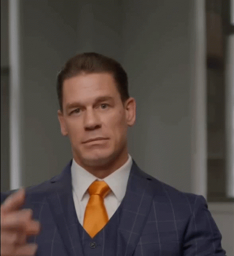 A Man In A Suit And Tie Is Pointing His Finger At His Eye GIF