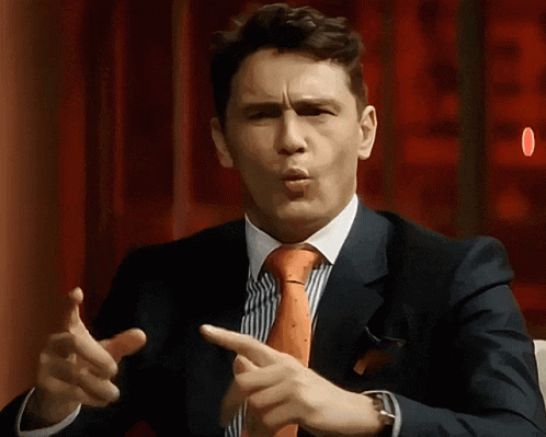 A Man In A Suit And Tie Is Pointing His Finger GIF
