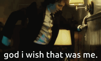 A Man In A Suit And Tie Is Reaching For A Lamp With The Words God I Wish That Was Me Written Below Him GIF