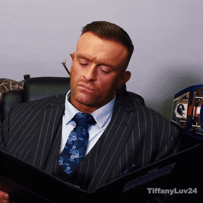 A Man In A Suit And Tie Is Reading A Book With Tiffanyluv24 In The Corner GIF