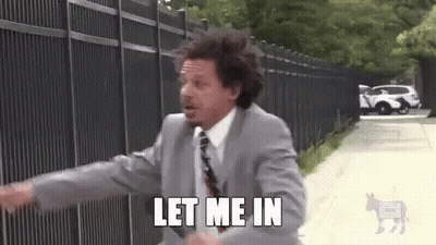 A Man In A Suit And Tie Is Running Down A Sidewalk And Says `` Let Me In '' . GIF