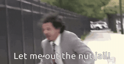 A Man In A Suit And Tie Is Running Down A Street And Says `` Let Me Out The Nut Jail '' . GIF