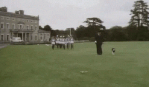 A Man In A Suit And Tie Is Running With A Dog In Front Of A Building GIF