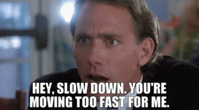 A Man In A Suit And Tie Is Saying `` Hey , Slow Down . You 'Re Moving Too Fast For Me . '' GIF