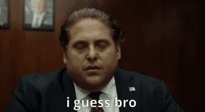 A Man In A Suit And Tie Is Saying `` I Guess Bro '' While Sitting In A Chair . GIF