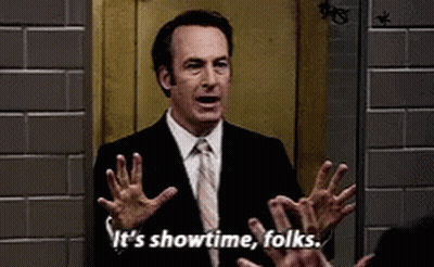 A Man In A Suit And Tie Is Saying It 'S Showtime Folks . GIF