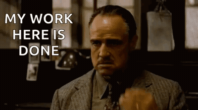 A Man In A Suit And Tie Is Saying `` My Work Here Is Done '' While Holding A Cigarette . GIF