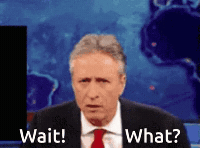 A Man In A Suit And Tie Is Saying Wait And What GIF