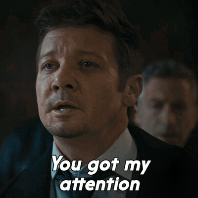 A Man In A Suit And Tie Is Saying " You Got My Attention " GIF