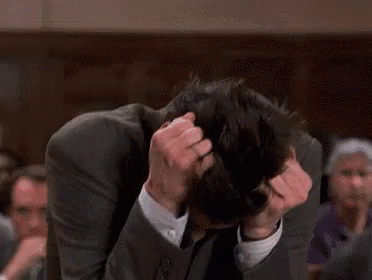 A Man In A Suit And Tie Is Scratching His Head While Standing In Front Of A Crowd . GIF
